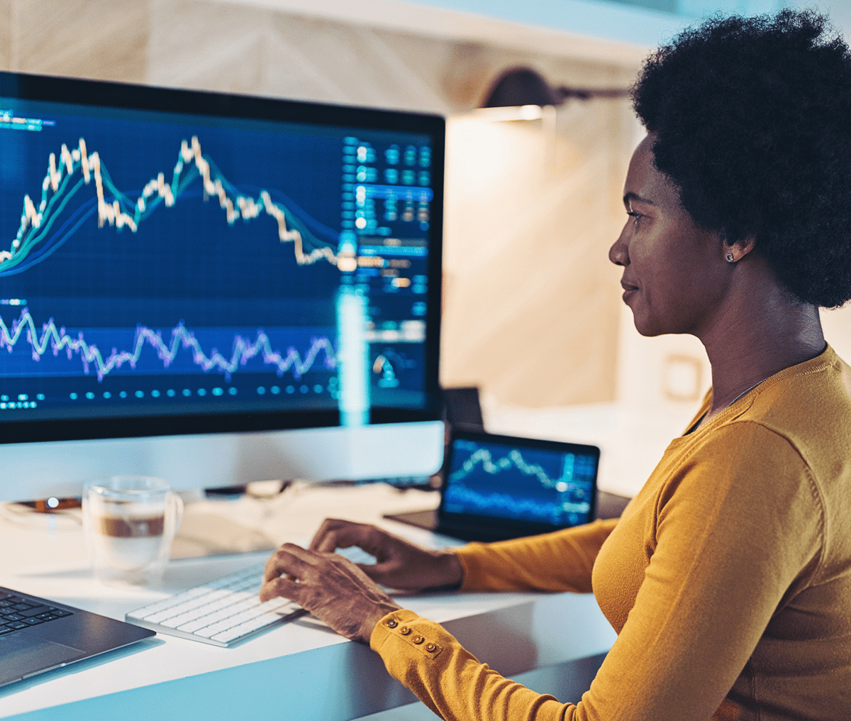 Woman analyzing financial graphs on computer.