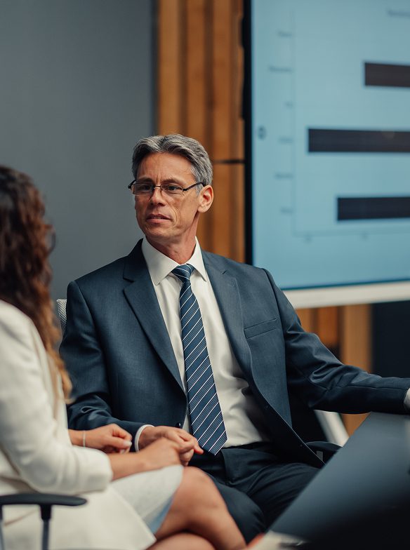 Man in suit talking during business meeting.