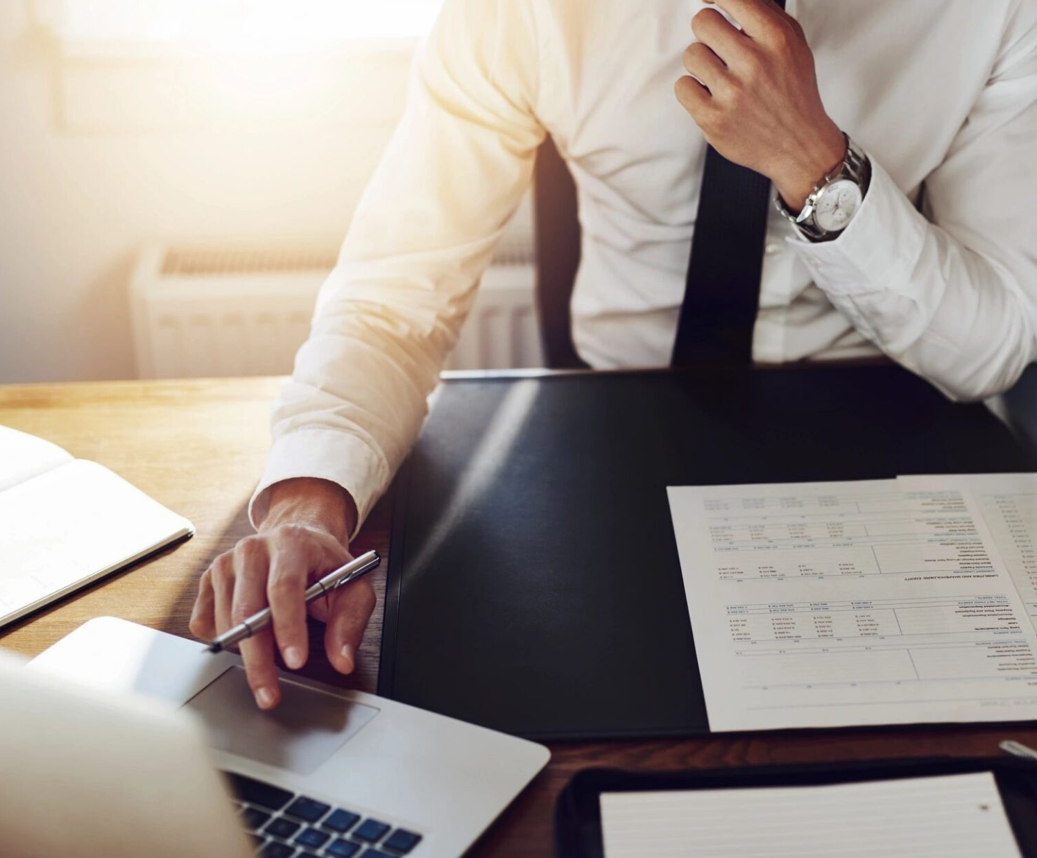 Businessman working at desk with laptop.